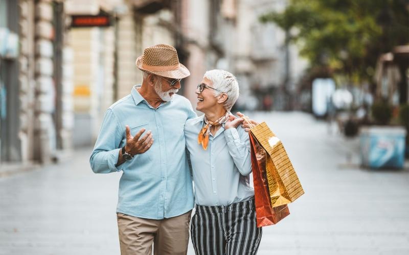 Close to the center of everything a man and woman holding shopping bags while walking